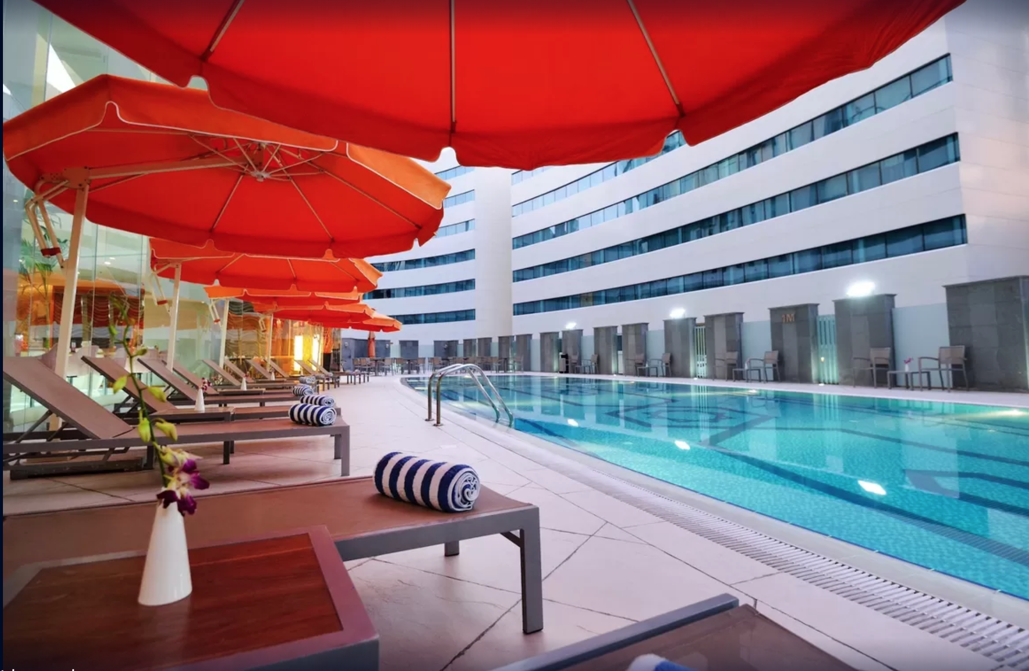 outdoor pool with lounge deck chairs at Holiday Villa Hotel & Residence City Centre Doha