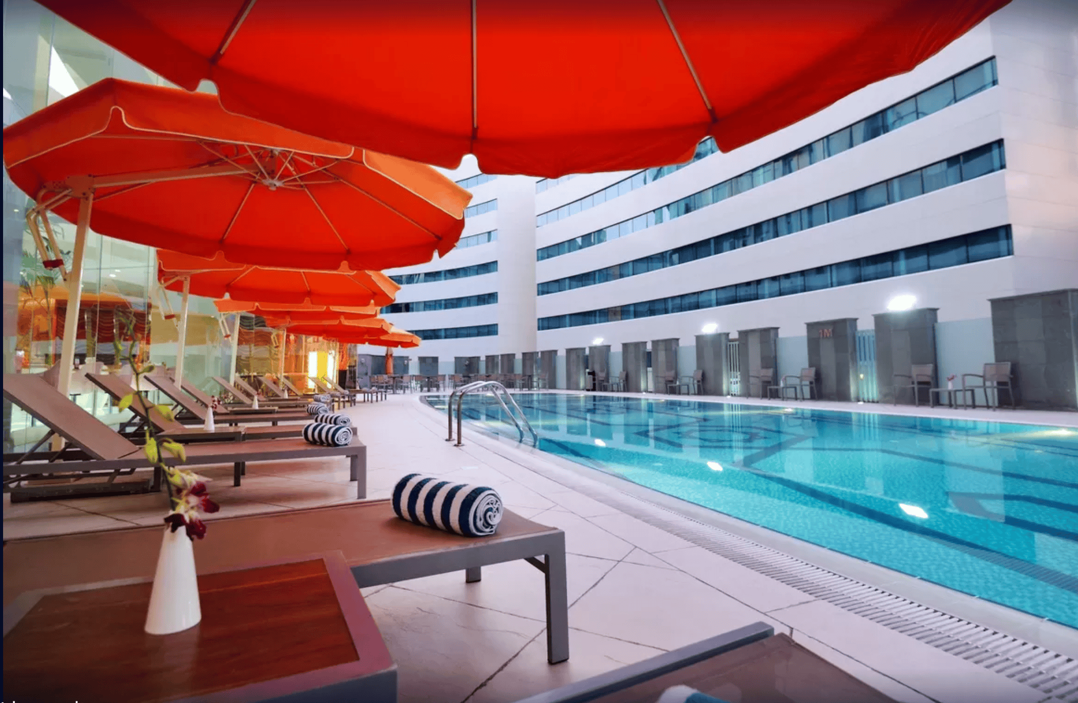 outdoor pool with lounge deck chairs at Holiday Villa Hotel & Residence City Centre Doha