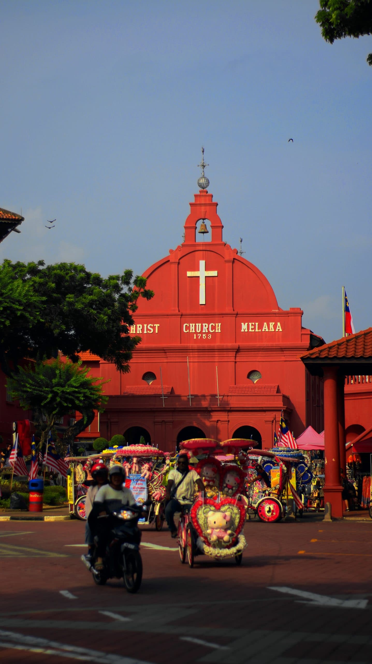 people riding decorated motorcycles in front of red church