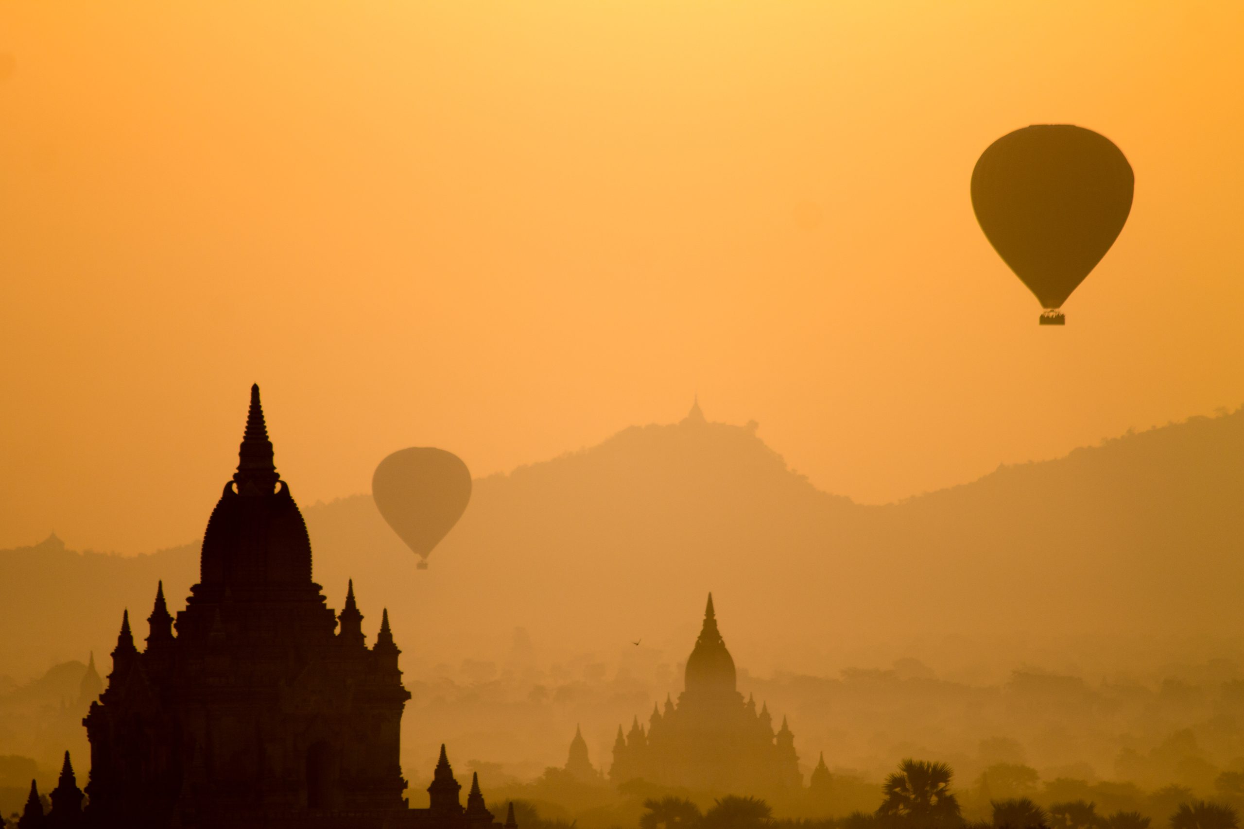 silhouette of temple and hot air balloons