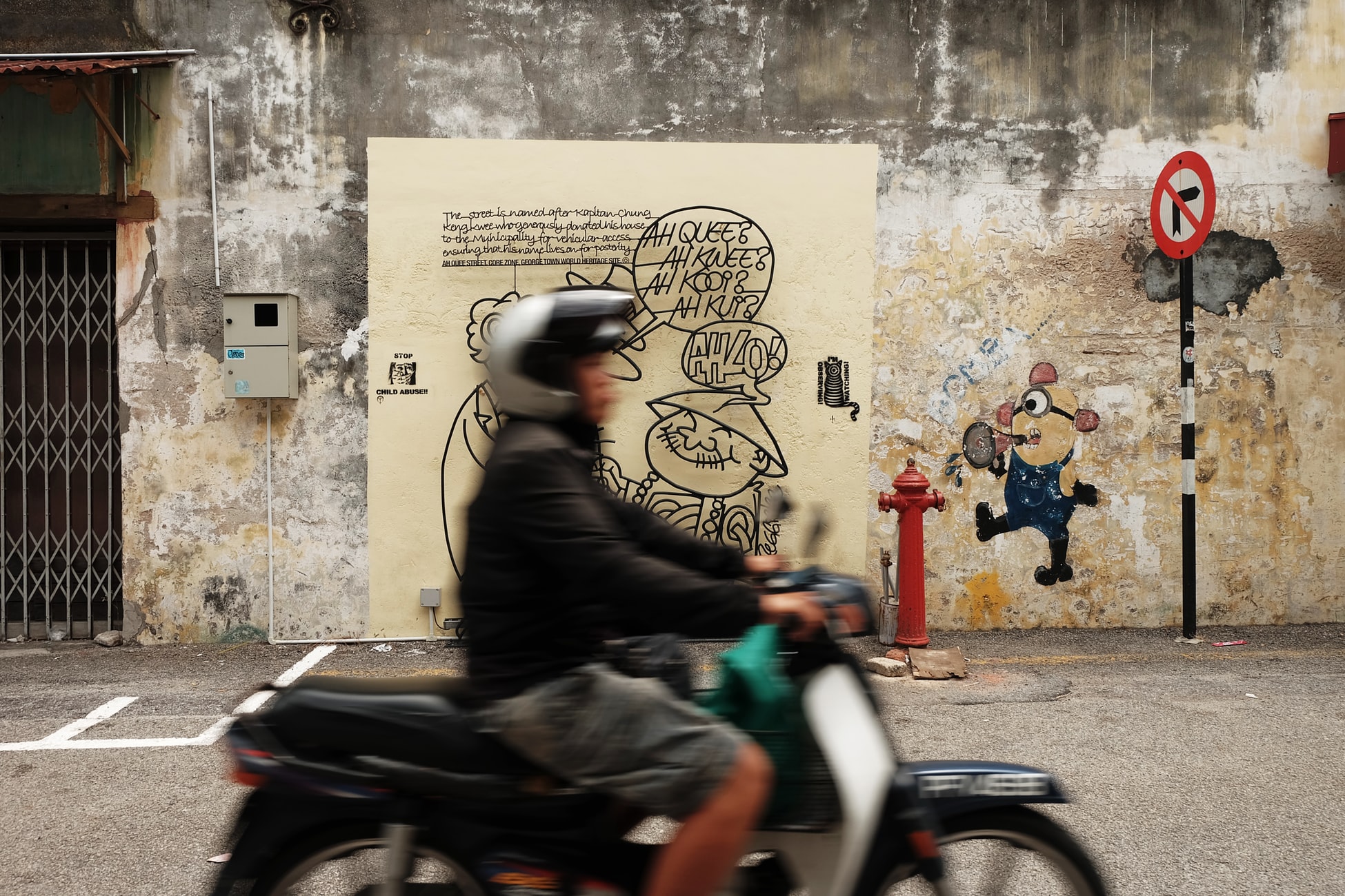 motorcyclist driving past mural